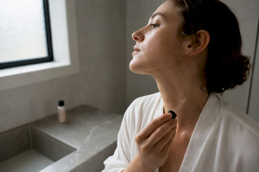 Mână aplicând un ser translucid în baie